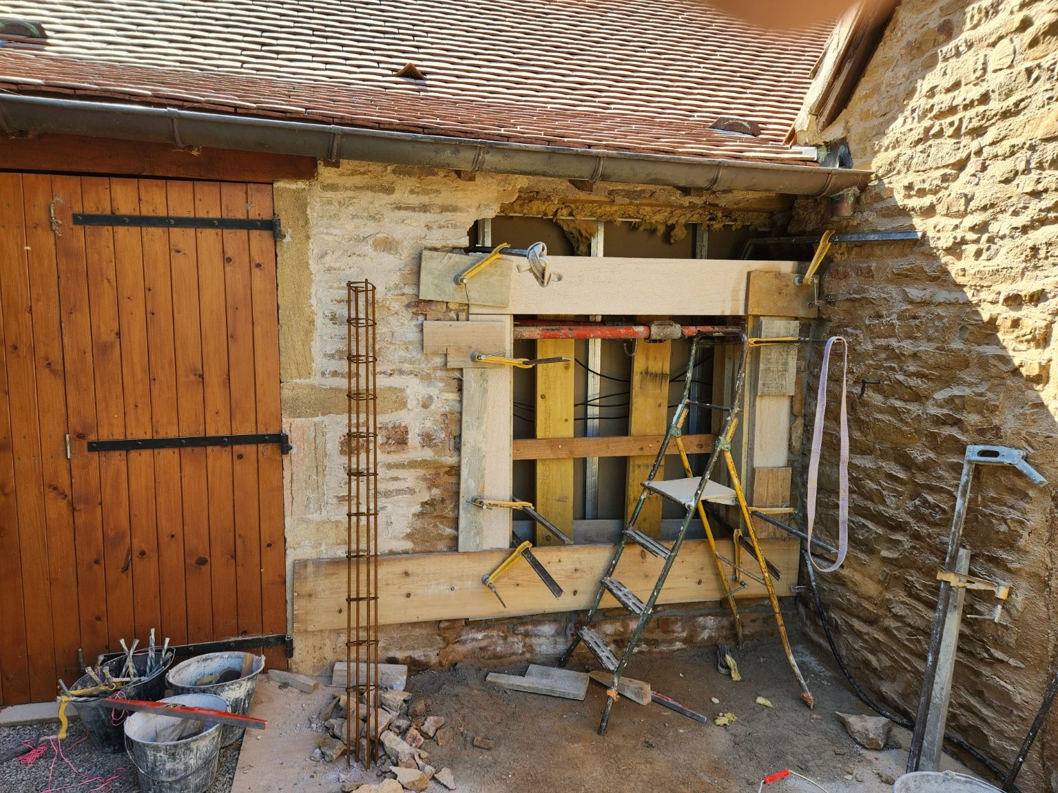 Pose en cours d’un encadrement en pierre taillée