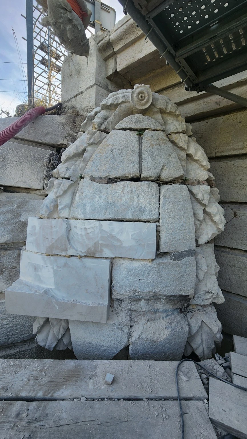 Grand médaillon sculpté en pierre en cours de restauration, vue de face